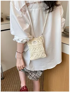 Handcrafted crochet phone bag in cream white shown on person in a casual setting