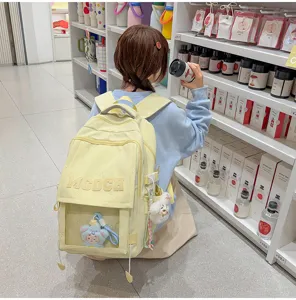 Mädchen trägt einen gelben japanischen Schulrucksack mit süßer transparenter Tasche