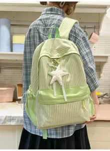 Detailansicht eines hellgrünen gestreiften Rucksacks mit Sternanhänger an einem Model.
