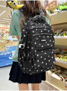 Close-up back view of a black backpack with white star pattern worn by a student in a store