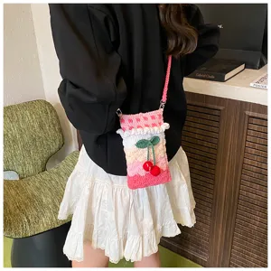 Nahaufnahme einer handgestrickten Häkel-Handytasche mit Kirschen und rosa Rüschen