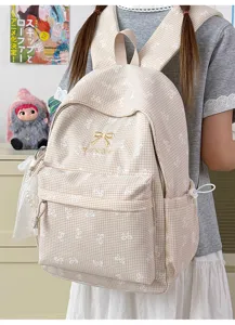 Vue détaillée d'un cartable à carreaux beige avec une broderie de nœud doré élégante.
