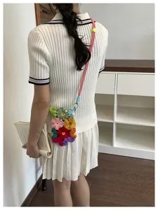 Modèle portant un sac de téléphone coloré en fleurs crochetées à la main, vue de dos