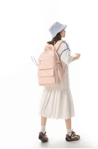 Full body view of a girl wearing a pink Japanese school backpack in a clean studio setting.