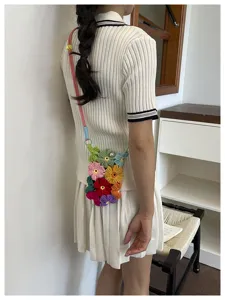 Vue détaillée d'un sac à téléphone en fleurs crochetées à la main porté en bandoulière