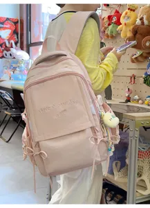 Vue détaillée du sac à dos rose avec broderie 'Have a good day' et pendentif lune en peluche
