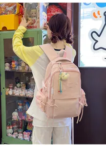 Vue de dos d'une fille portant un sac à dos scolaire rose brodé dans un magasin de jouets