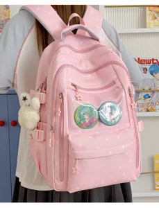 Détail d'un sac à dos rose à motif d'étoiles avec pins anime et breloque