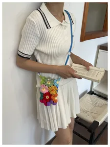 Vue détaillée d'un sac de téléphone en fleurs au crochet fait main porté par un mannequin