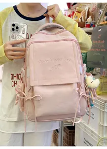 Gros plan d'un sac à dos rose pour étudiant avec broderie 'Have a good day' détaillé