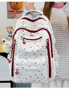 Vue détaillée d'un sac à dos blanc pour filles avec imprimé d'étoiles rouges