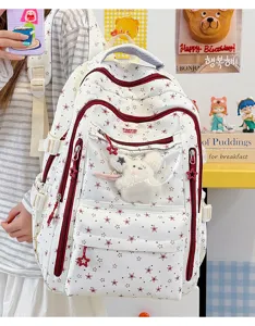 Détail d'un sac à dos blanc à étoiles avec poche transparente et peluche