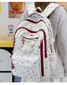 Détail d'un sac à dos scolaire avec motifs d'étoiles rouges et poche transparente