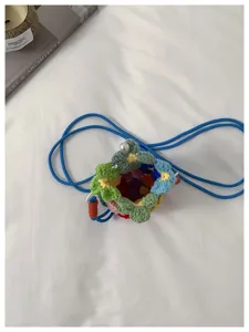 Vue de dessus d'un sac à bandoulière en fleurs tricotées à la main avec cordon bleu