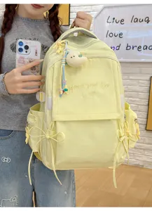 Détail du sac à dos scolaire jaune avec broderie et mignon pendentif en peluche
