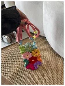 Vue détaillée d'un sac de téléphone en fleurs crochetées main aux motifs tricotés