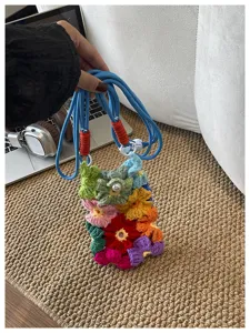 Vue détaillée des fleurs au crochet faites main sur un sac bandoulière pour téléphone