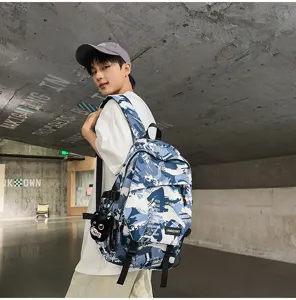 Blauer und weißer Graffiti Rucksack im urbanen Stil, getragen von einem Modell im Freien