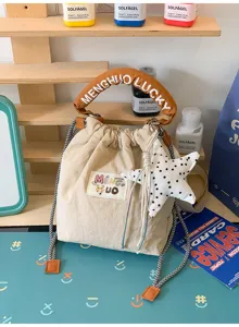 Vista dettagliata di una simpatica borsa a secchiello beige con ciondolo a stella