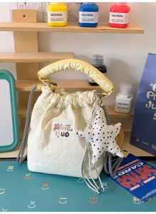 Carina borsa a secchiello crema con manico giallo e ciondolo a stella a pois.