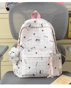 Detail view of pink plaid school backpack with cute cartoon bear patterns and plush charm