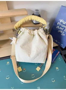 Vista dettagliata della borsa a secchiello in nylon crema con manico giallo arricciato