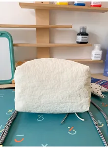 Vista dettagliata che mostra l'esclusiva texture increspata di questa borsa bianca.