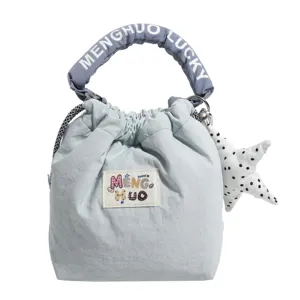 Vista frontale di una borsa a secchiello azzurro pastello con toppa a cartoni animati.