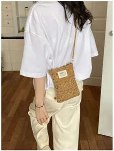 Detail of handmade crochet phone bag worn by a model in a casual setting