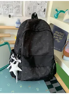 Detailansicht des schwarzen gestreiften Rucksacks mit Schleifenmustern und Sternen-Plüschanhänger