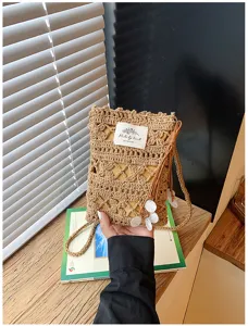 Handmade hollow-out crochet phone bag with delicate shell accents and woven strap