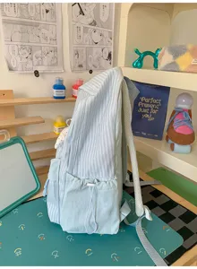 Seitenansicht des hellblau gestreiften Rucksacks mit Schleifenmuster und Seitentaschen