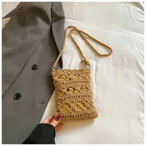 Close-up detail of a handmade hollow crochet women's phone bag in natural straw color