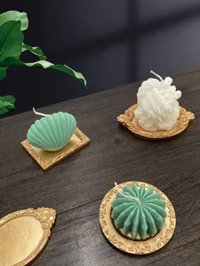 Detailed shot of decorative scented candles and vintage resin trays on wooden table background.