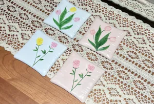 Square resin floral coaster set with 3D embossed tulip and rose design for home decor table.