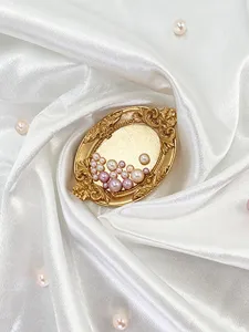 Close-up detail of vintage gold resin pearl jewelry tray decorative photo prop.