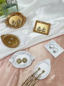Close up of vintage resin earring display tray with exquisite relief design for jewelry props.