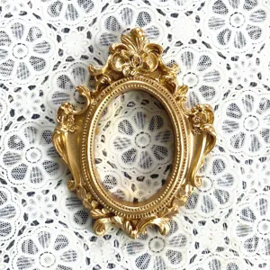 Piccola cornice ovale dorata in resina stile vintage come supporto decorativo per gioielli.