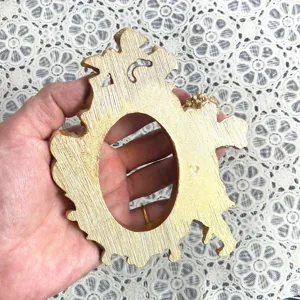 Vista dettagliata della mini cornice ovale in resina vintage, espositore per gioielli.
