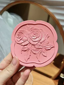 Close-up of pink irregular resin jewelry dish with detailed embossed rose pattern design.