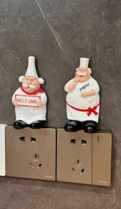 Cute cartoon chef resin plug holder wall hook for power cord storage and home decor.
