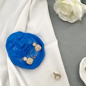 Blue resin human face jewelry dish and storage tray for desktop decoration and aesthetic home decor.