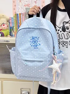 Detail eines hellblauen Schulrucksacks mit weißem Sternmuster und Sternanhänger