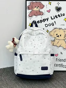 Nahaufnahme eines weißen Schulrucksacks mit Sternenmuster und einem süßen Plüschbären-Anhänger