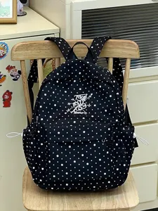 Detailansicht eines modischen schwarzen Schulrucksacks mit weißem Sternen und Punktmuster