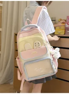 Dettaglio di uno zaino ita bag rosa e giallo indossato da una studentessa, design color-block