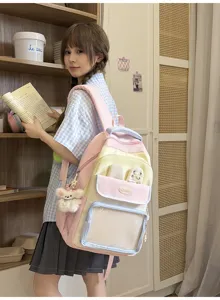 Studentessa asiatica con uno zaino in nylon rosa e giallo pastello in una biblioteca