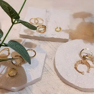 White jewelry display tray marble texture photography props and ring storage pad setup.