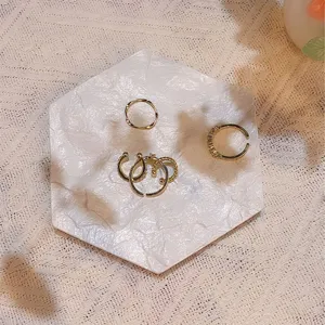 White marble texture hexagonal jewelry tray detail, minimalist photo prop storage display.