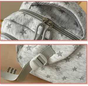 Detailed macro view of dual zippers and plastic adjustment buckle on star print backpack